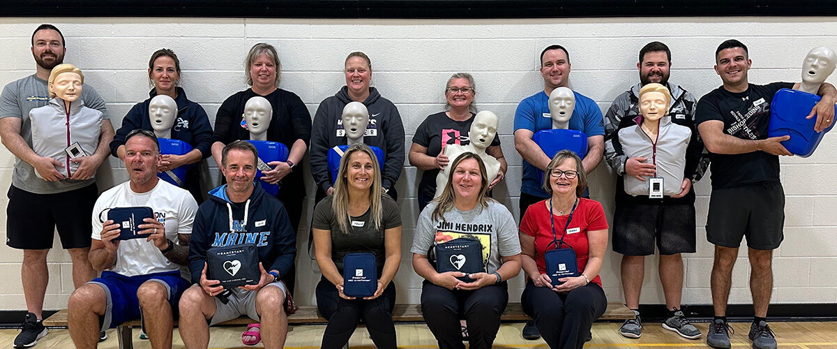 Teachers holding CPR mannequins